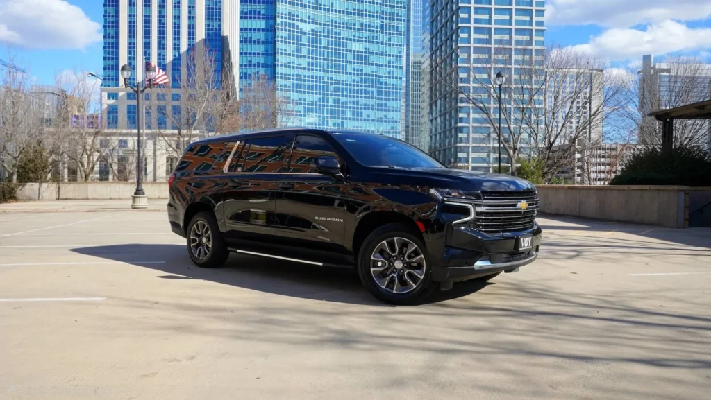 Executive SUV ready for client pickup in urban center backdrop.