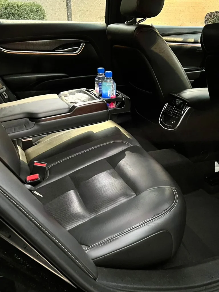 Luxurious VOY sedan interior with plush seating and complimentary water bottles.